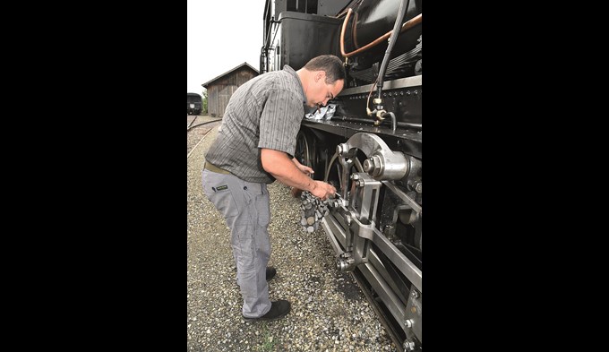 Schmieren und Salben hilft allenthalben: Heizer Robin Heimann füllt die Ölstellen der beweglichen Teile am Fahrwerk auf. (Foto Daniel Zumbühl)