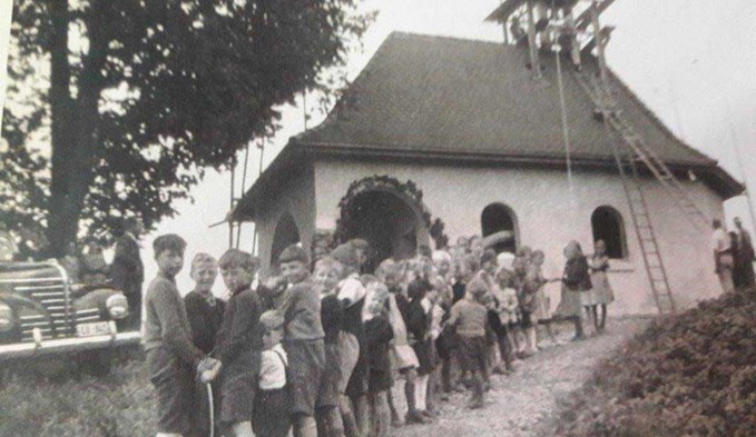 1948 wird der Kirchturm mit Unterstützung einer grossen Kinderschar aufgerichtet. Foto:Josef Egli/Archiv