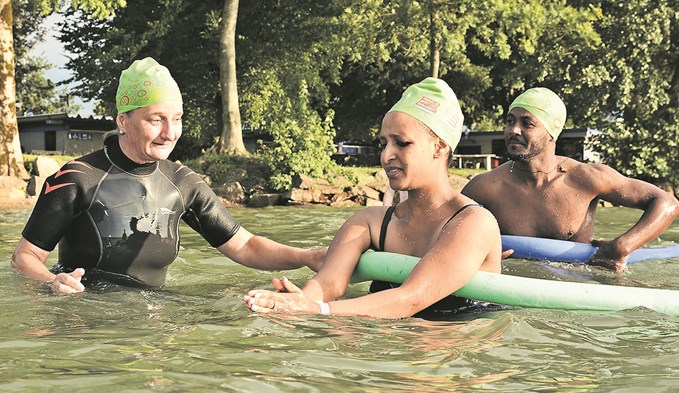 SLRG-Expertin Cornelia Bühlmann aus Sempach zeigt Fiori und Habtom (von links) das Brustschwimmen. (Foto: Manuel Arnold)