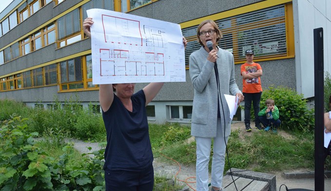 Bildungsvorsteherin Heidi Schilliger (rechts) zeigte den Schulkindern und Gästen des Spatenstichs einen Plan des Erneuerungsbaus. Foto Daniel Zumbühl