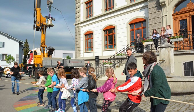 Mit vereinten Kräften zogen die Schulkinder die neue Glocke zum Türmchen des ronovierten Dorfschulhauses hoch. Foto Daniel Zumbühl
