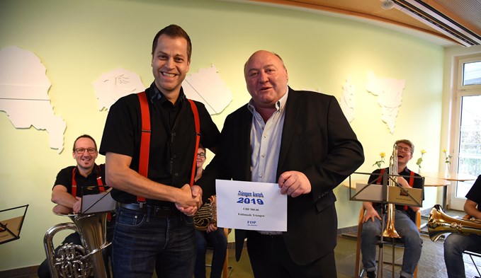 FDP-Ortsparteipräsident Peter Häfeli überreicht den Preis an Feldmusik Vizepräsident Martin Kehl. (Foto Thomas Stillhart)