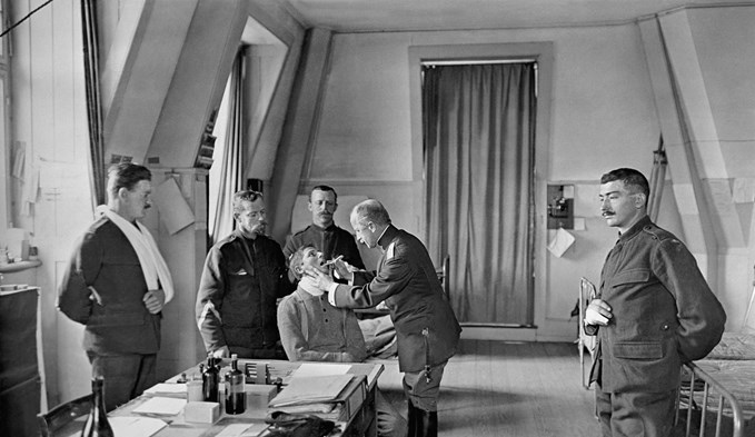 Ein Truppenarzt untersucht Schweizer Armeeangehoerige im Ersten Weltkrieg (Foto Keystone)