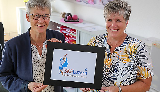 Die neue Geschäftsstellenleiterin Regula Heuberger (links) und Arbeitskollegin Irene Regli präsentieren das modernisierte Logo des SKF Luzern. (Foto zvg)