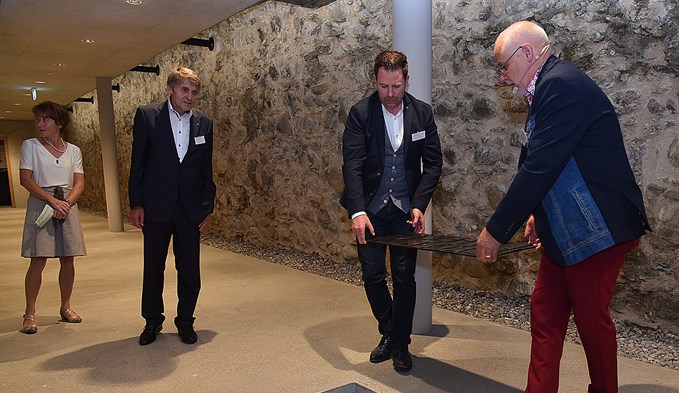 Baukommissionspräsident Adrian Mehr (2. v. r.) und Kirchenrat Carlo Piani legten zwei Zeitkapseln in den Boden des Foyers und deckten sie mit einer Metallplatte zu. (Foto Daniel Zumbühl)