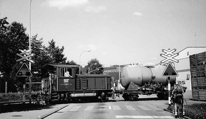 Die Diesellok Em 2/2 Nr. 2 der Sursee–Triengen-Bahn rangiert 1987 einen Güterwagen über die mit einer selten gewordenen Asega-Wechselblinklichtanlage gesicherte Zeughausstrasse. (Foto Daniel Zumbühl)
