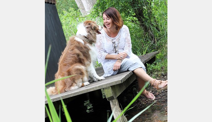 Carole Sarbach ist mit einem Hund des Hauses im Garten. (Foto zVg)