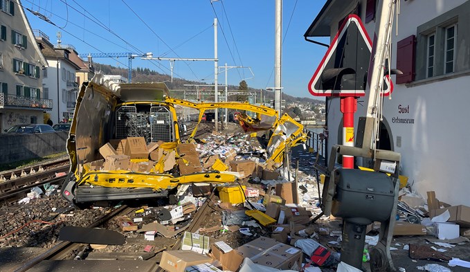Damit fing die Odyssee an: völlig zerstörter Post-Lieferwagen und viele verstreute Pakete auf dem Bahnübergang in Horgen.  (Foto Kantonspolizei Zürich)