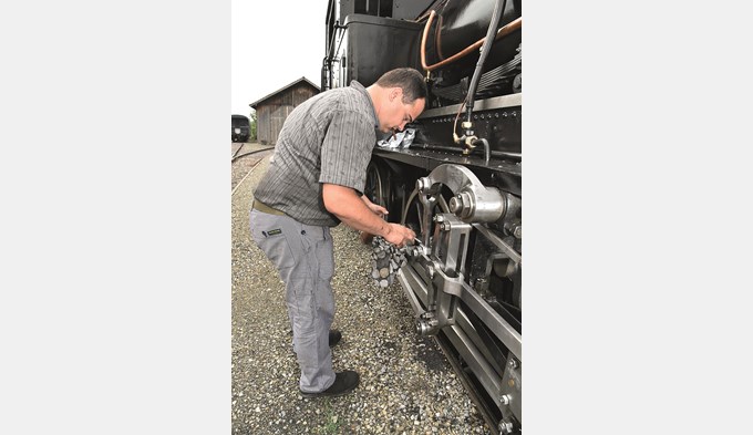 Schmieren und Salben hilft allenthalben: Heizer Robin Heimann füllt die Ölstellen der beweglichen Teile am Fahrwerk auf. (Foto Daniel Zumbühl)
