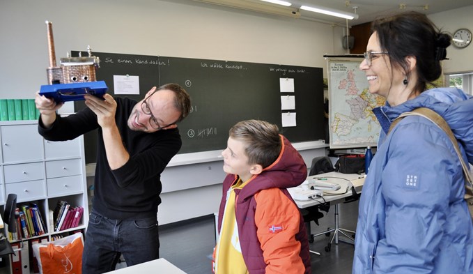 Geschichtslehrer André Grüter demonstriert Julia und Robin Torgler aus Sempach das Dampfmaschinenmodell. (Foto David Lienert)