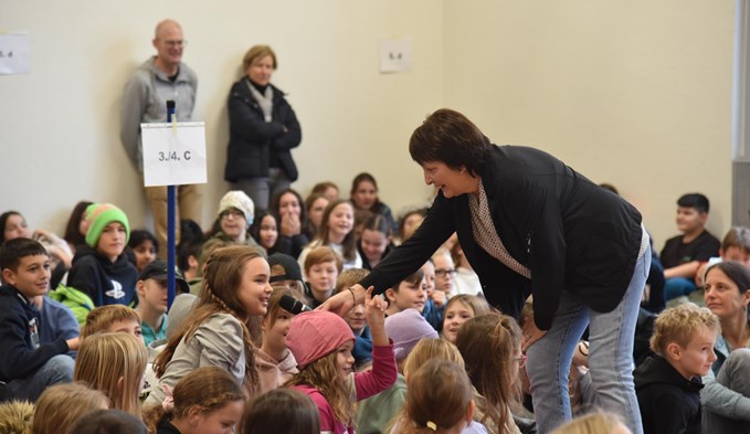 Beatrice Cozzio reichte den Schulkindern das Mikrophon, damit diese ihre Fragen dem Ex-Radprofi stellen konnten. (Foto Franziska Kaufmann)