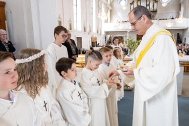 Erich Hausheer spendet den Rainer Kindern die heilige Kommunion. (Foto Margrit Burri)