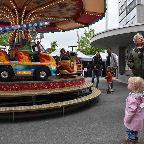 
									Zukunftsaussichten: Die kleine Marktbesucherin bestaunt das Fahrgeschäft. Bild: Foto Céline Estermann-Erni
								