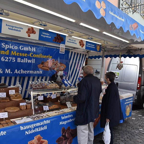 
									Helmuth Achermann bedient Kundschaft an seinem Confiserie-Stand. Bild: Céline Estermann-Erni
								