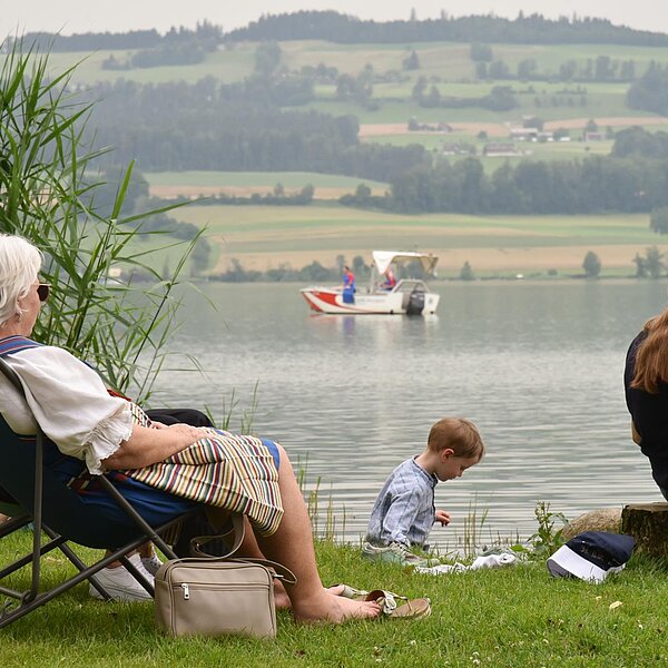 
									Am Freitag und Samstag kamen die Trachtenträgerinnen und -träger ordentlich ins Schwitzen. Man liess sich am See von der Brise erfrischen. Bild: Foto Franziska Kaufmann
								