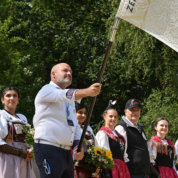 
									Am Freitagnachmittag wurde OK-Präsident Toni Bussmann traditionell die Verbandsfahne überreicht. Bild: Foto Franziska Kaufmann
								