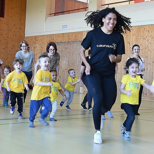 
									Die schnellste Frau der Schweiz, Mujinga Kambundji, besuchte in Büron «Miteinander Turnen» MiTu mit Leiterin Astrid Müller und drei- bis fünfjährigen Kindern.  Bild: Foto Thomas Stillhart
								